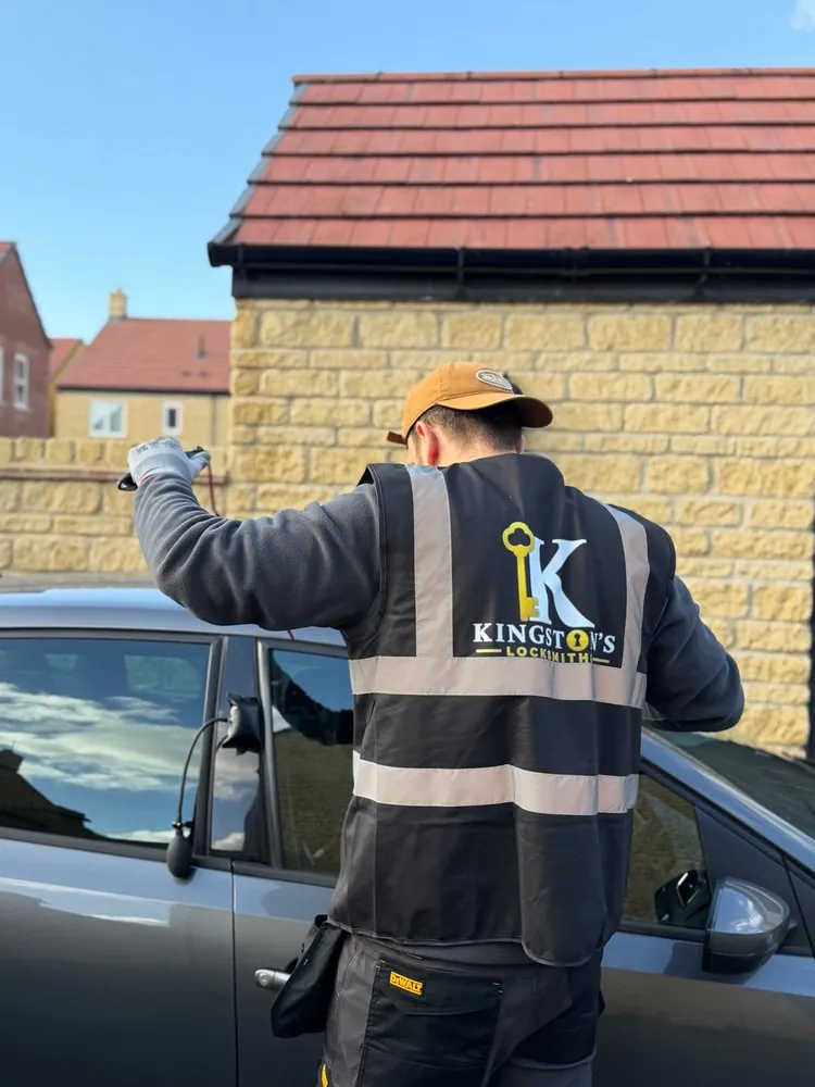 Kingston's Locksmiths opening a locked car with an air wedge and long-reach tool, using non-destructive entry