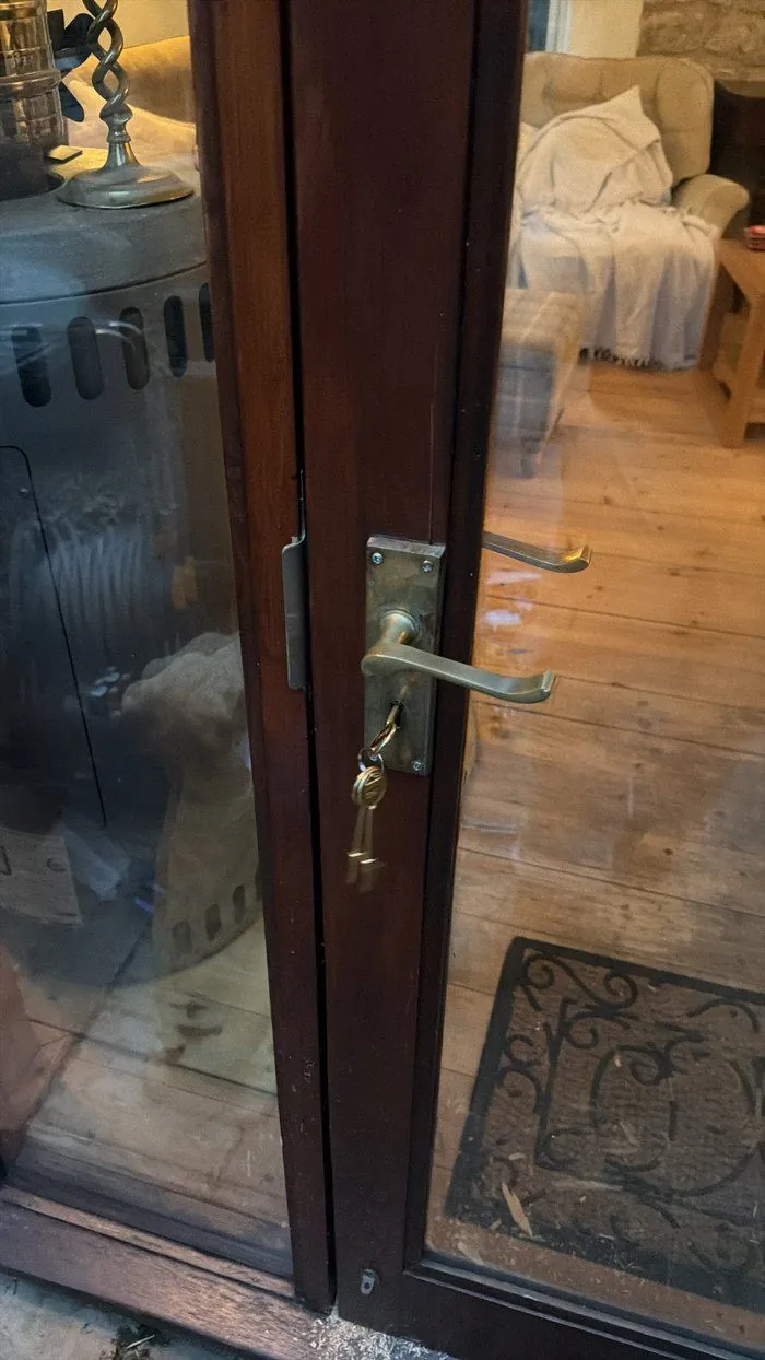 Old worn brass lever handle and lock on a glazed timber door in Woodstock