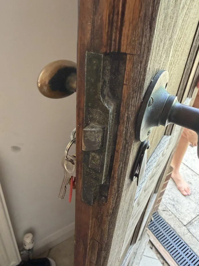 Old mortice lock and latch on a solid wooden period door in North Leigh